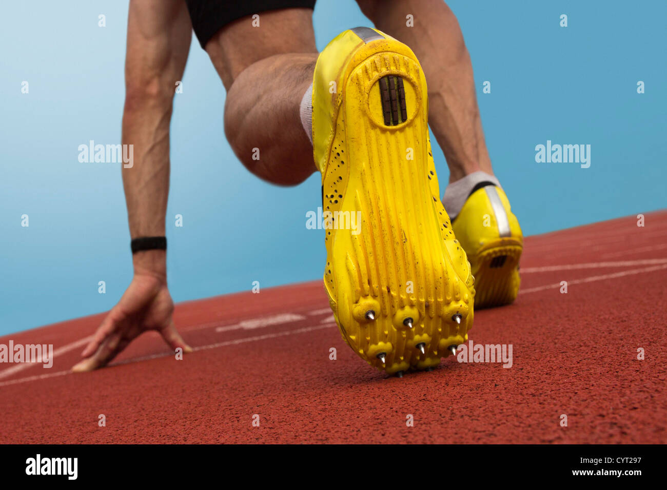 Sprinter with spikes is in start position Stock Photo