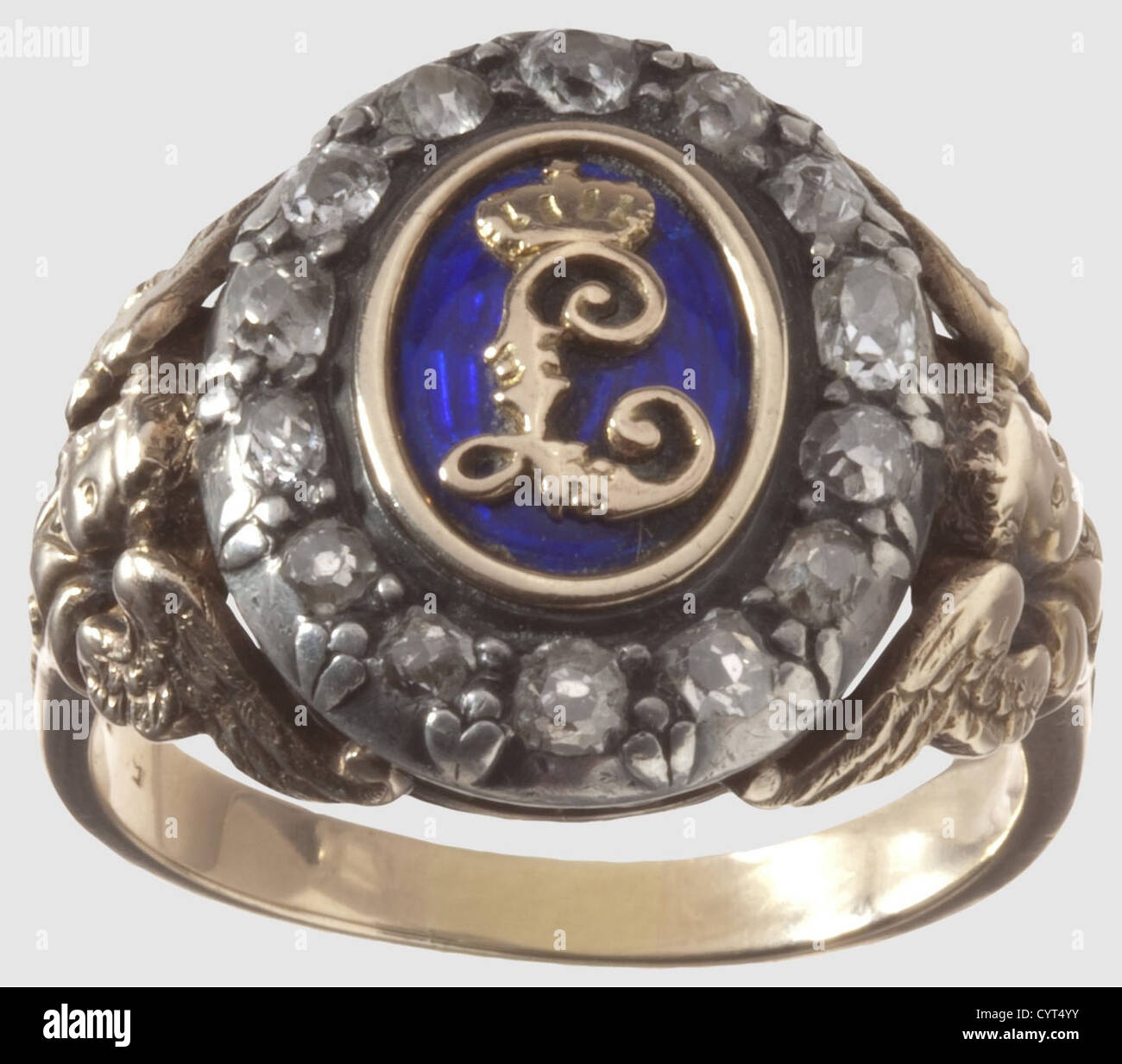 King Ludwig II of Bavaria(1845-1886),a diamond set gift ring for a distinguished Munich citizen Red gold,blue enamelled centre with applied gold cypher 'L',the hoop of white gold,set with 14 old European cut diamonds,the shoulders embellished with cupids and decorations. The inside of the ring stamped '585'. Large ring size for men. Weight 10.8 g. The ring comes from private ownership(further details provided to the buyer if desired)and has never been on the market before,a used piece of jewellery of strong appeal,historic,historical,19th century,B,Additional-Rights-Clearences-Not Available Stock Photo