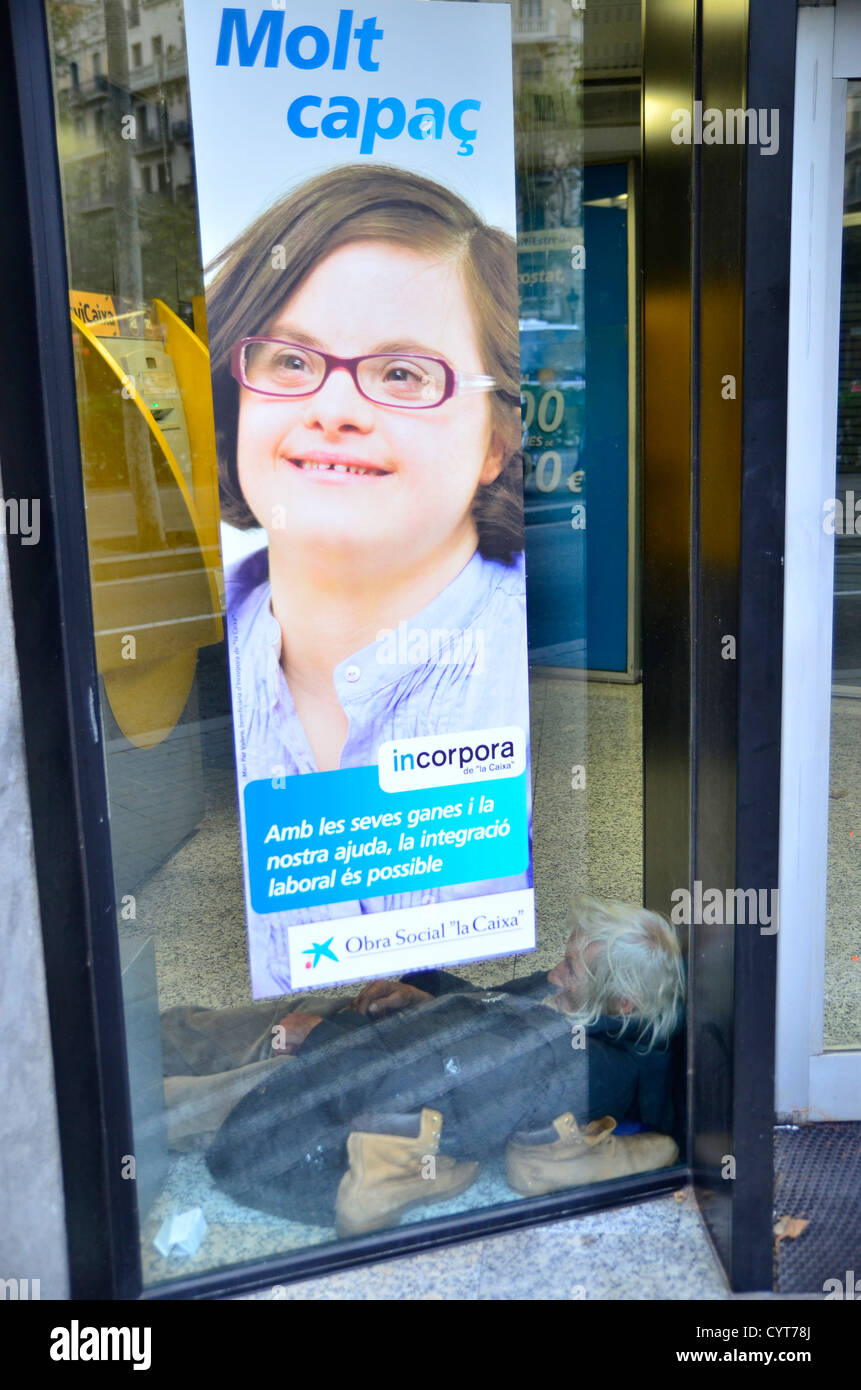 Outcast in a ATM with ironic sign: 'with our help, your integration is possible' Stock Photo