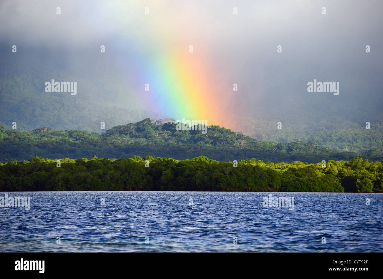 Rainbow, rain clouds, and mist over coastal jungle, Pohnpei, Federated States of Micronesia Stock Photo