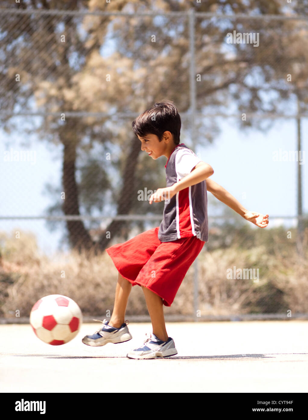Young kid in action enjoying soccer, outdoors Stock Photo