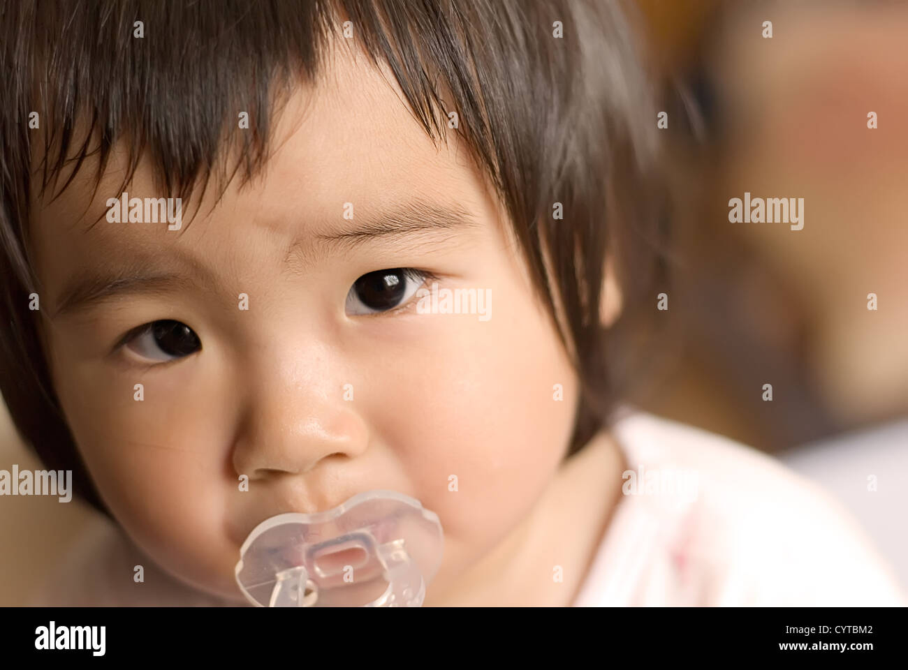 An asia baby was watching somewhere out there. Stock Photo