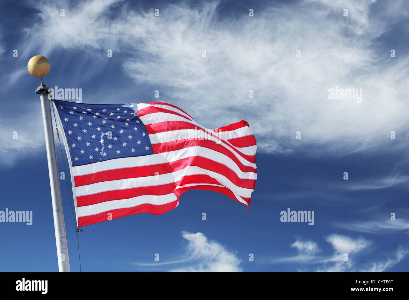 Windblown flag of the United States of America over sky background Stock Photo