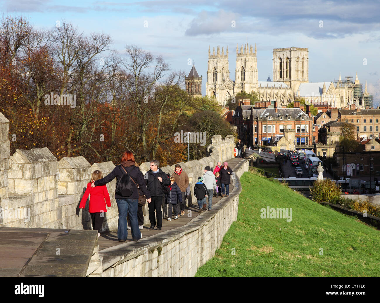 People walking along York City walls with York Minster in the