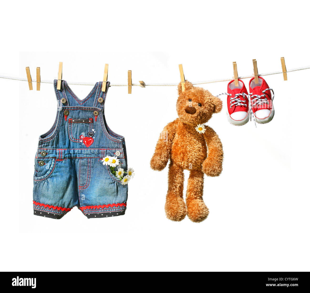 Child's clothes with teddy bear on clothesline on white Stock Photo