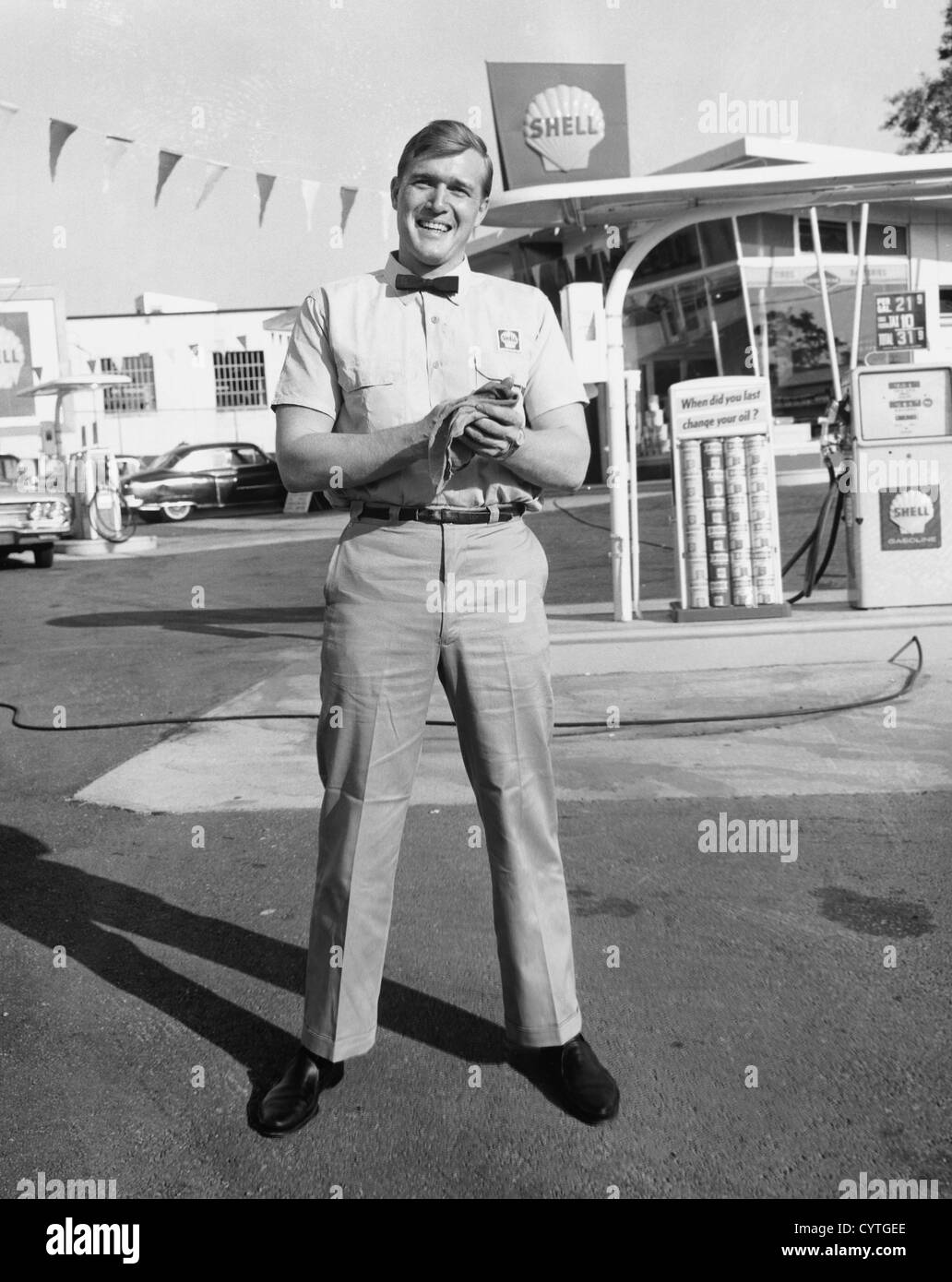 Gas station attendant standing in front of station Stock Photo