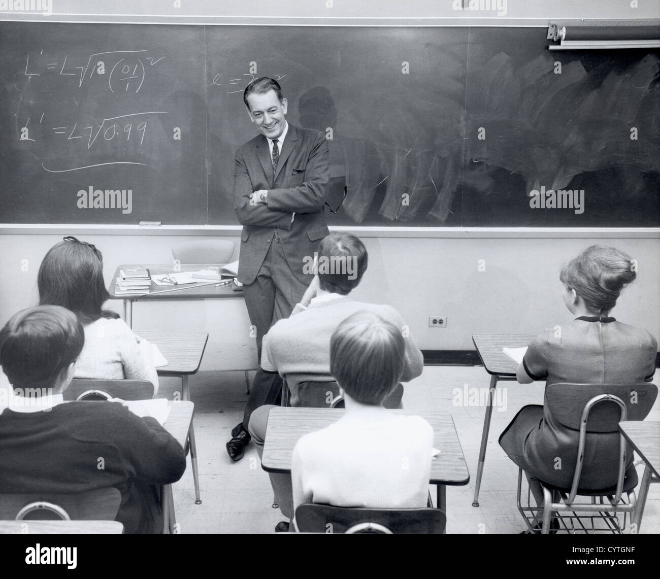 Math teacher talking to students in classroom Stock Photo