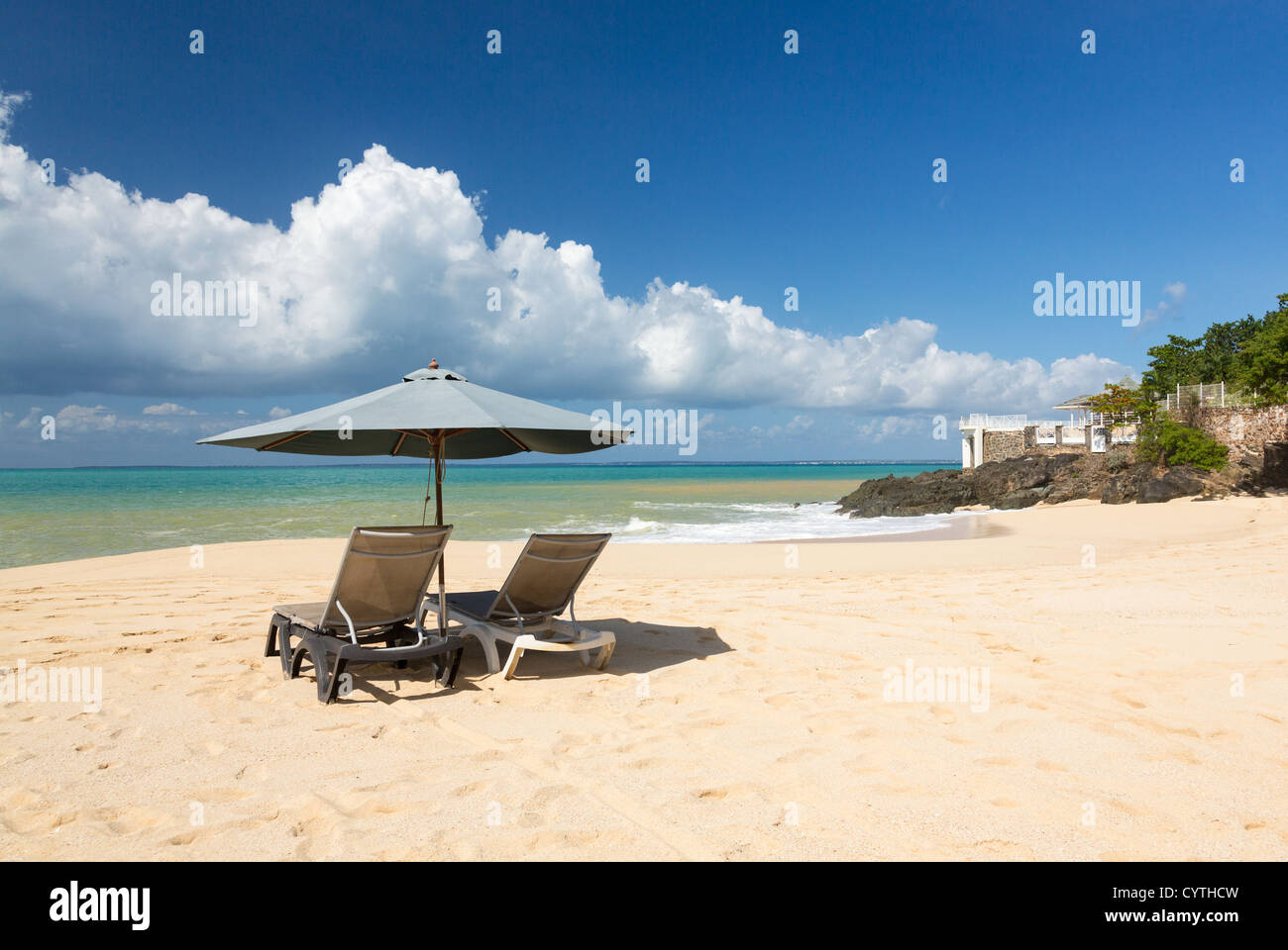Reclining beach loungers and sun umbrella on Baie Rouge tropical beach on St Maarten / St Martin, Caribbean Stock Photo