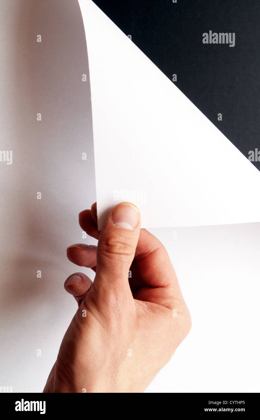 hand turning over blank sheet of paper Stock Photo