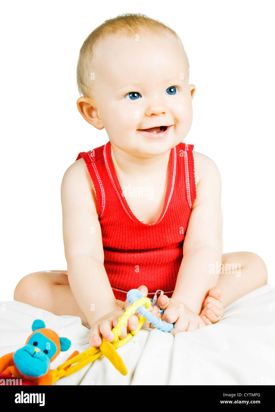 A blond baby boy with blue eyes sitting up smiling Stock Photo