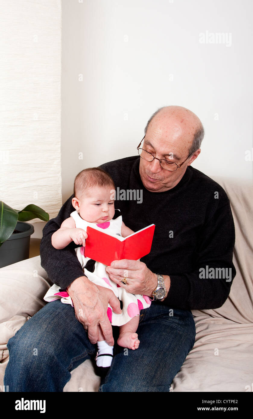 Grandpa reading red book to baby girl Stock Photo Alamy