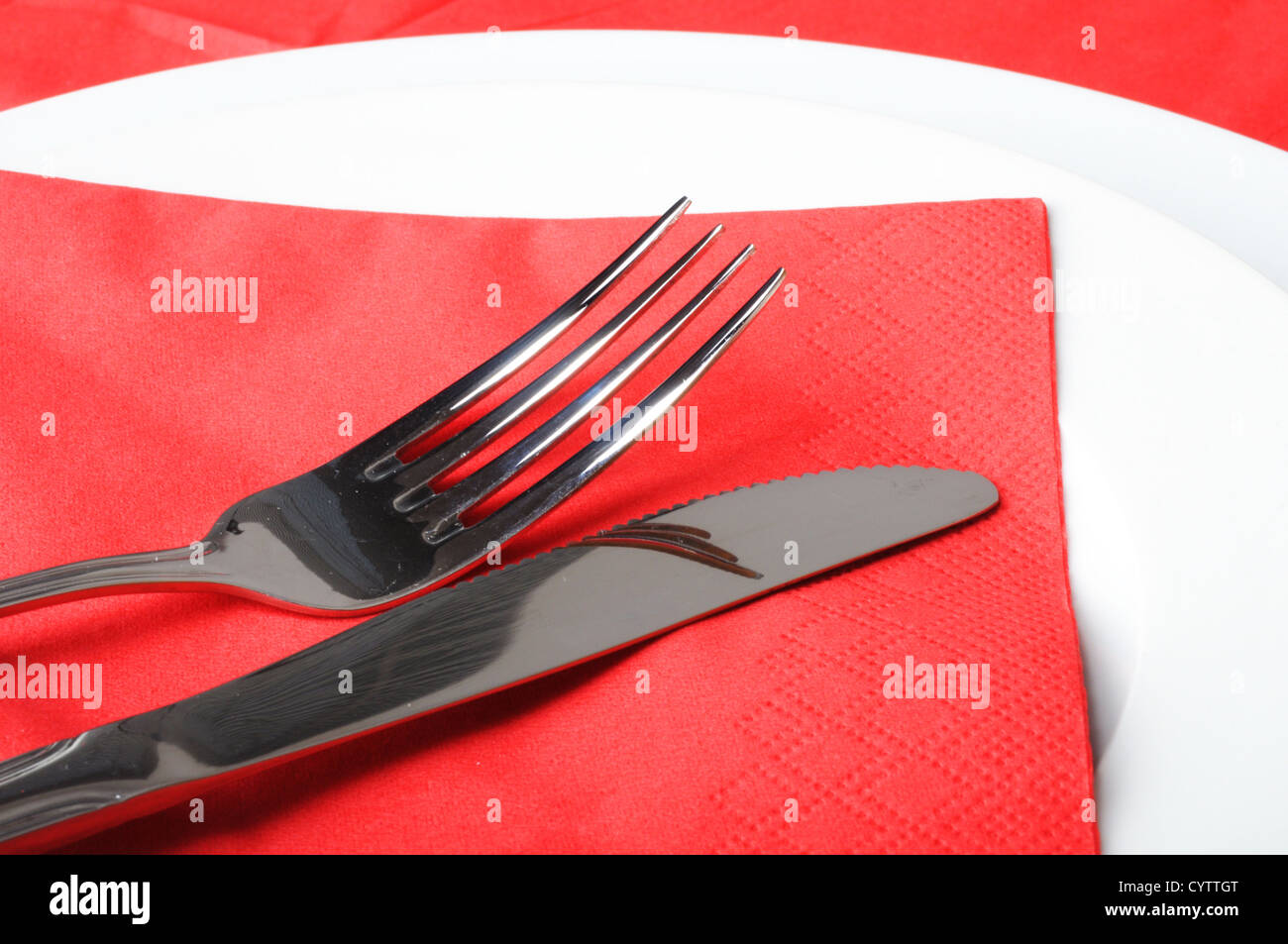 stainless fork knife and plate set on a table Stock Photo - Alamy