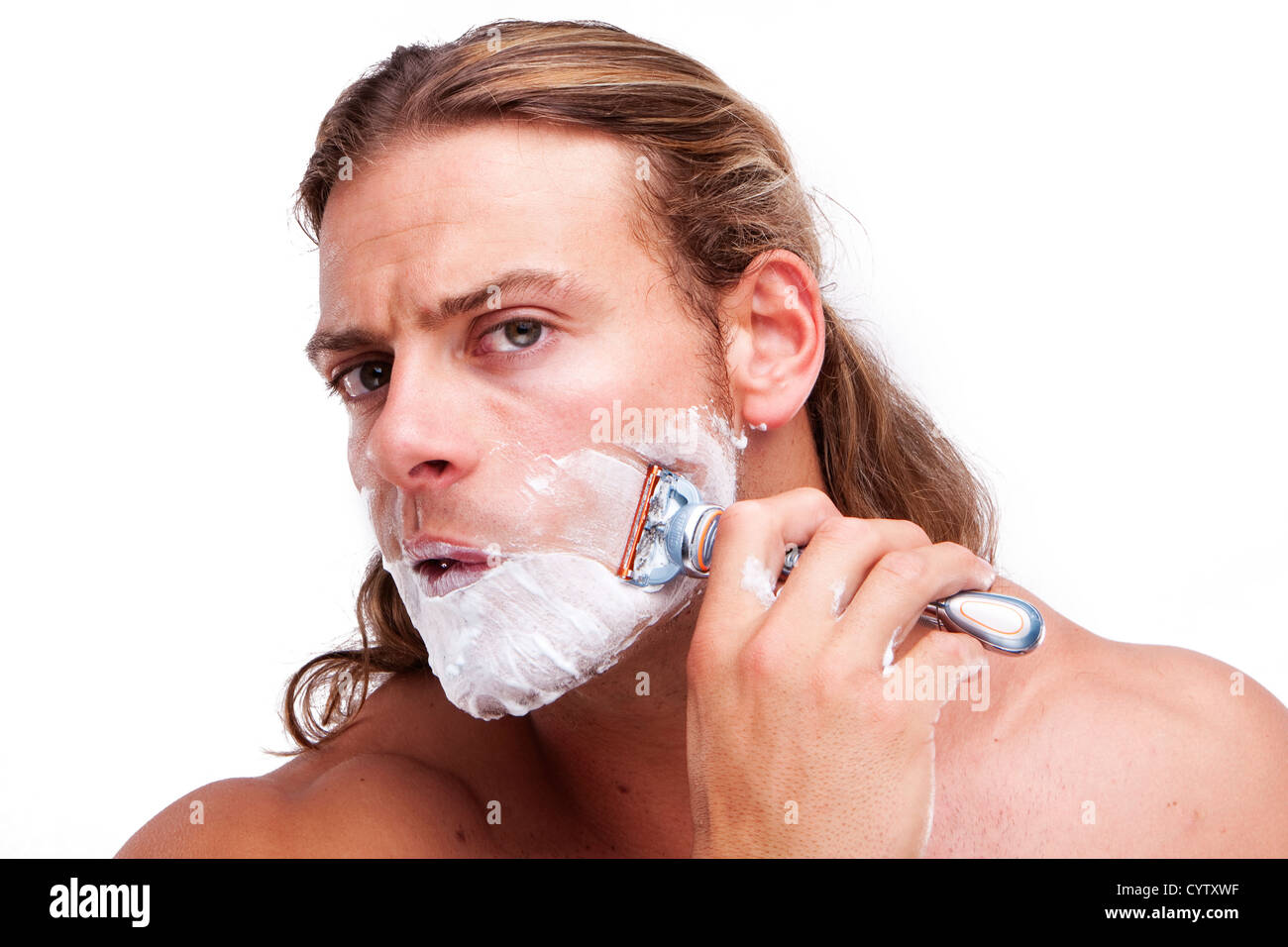 Portrait of a young handsome man shaving as part of his morning routine. Stock Photo