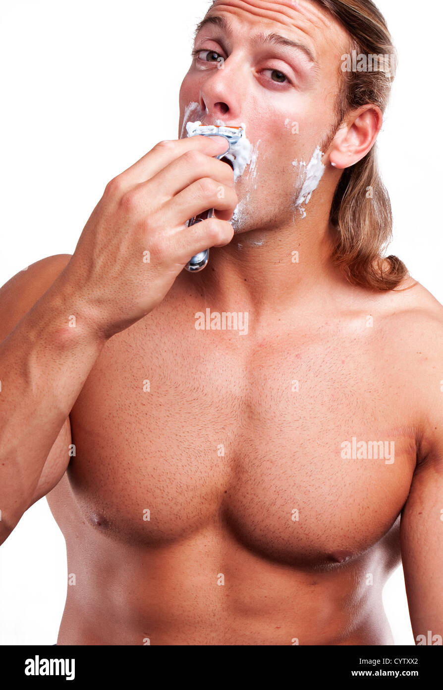 Portrait of a young handsome man shaving as part of his morning routine. Stock Photo