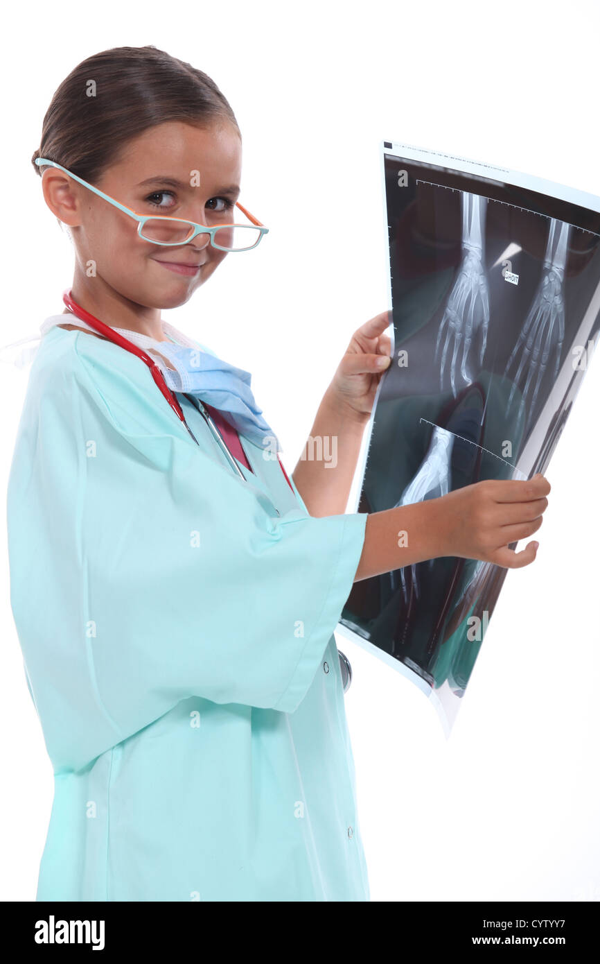Little girl wearing hospital scrubs and examining an xray Stock Photo