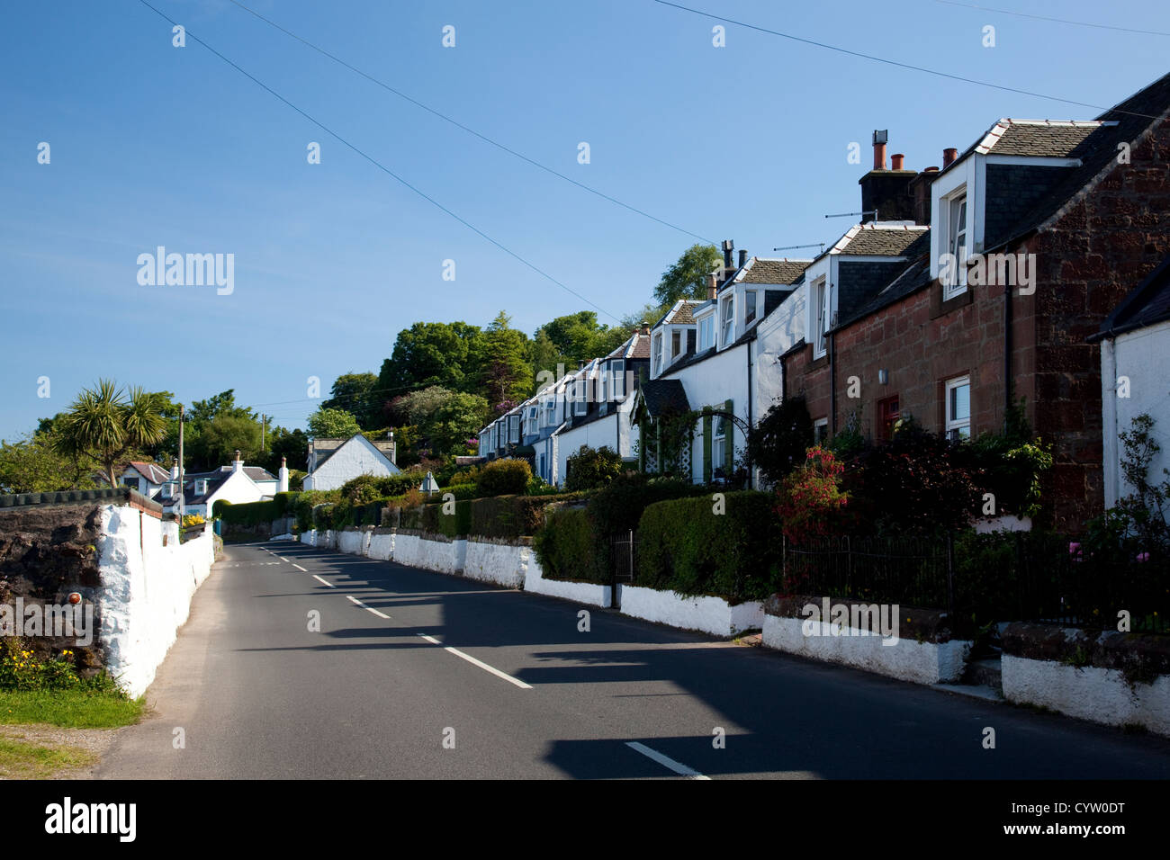 View of a row of houses alongside the road in the coastal village of Corrie, Isle of Arran, Scotland, UK Stock Photo