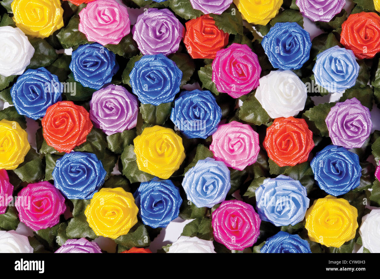 many-coloured plastics roses on a table Stock Photo - Alamy