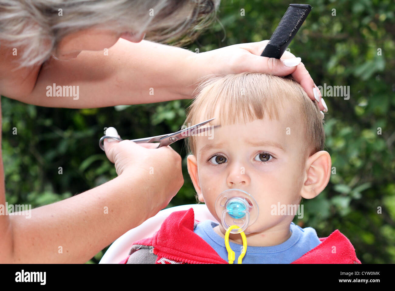 hair cutting first one-year-old child - trimming bangs Stock Photo - Alamy