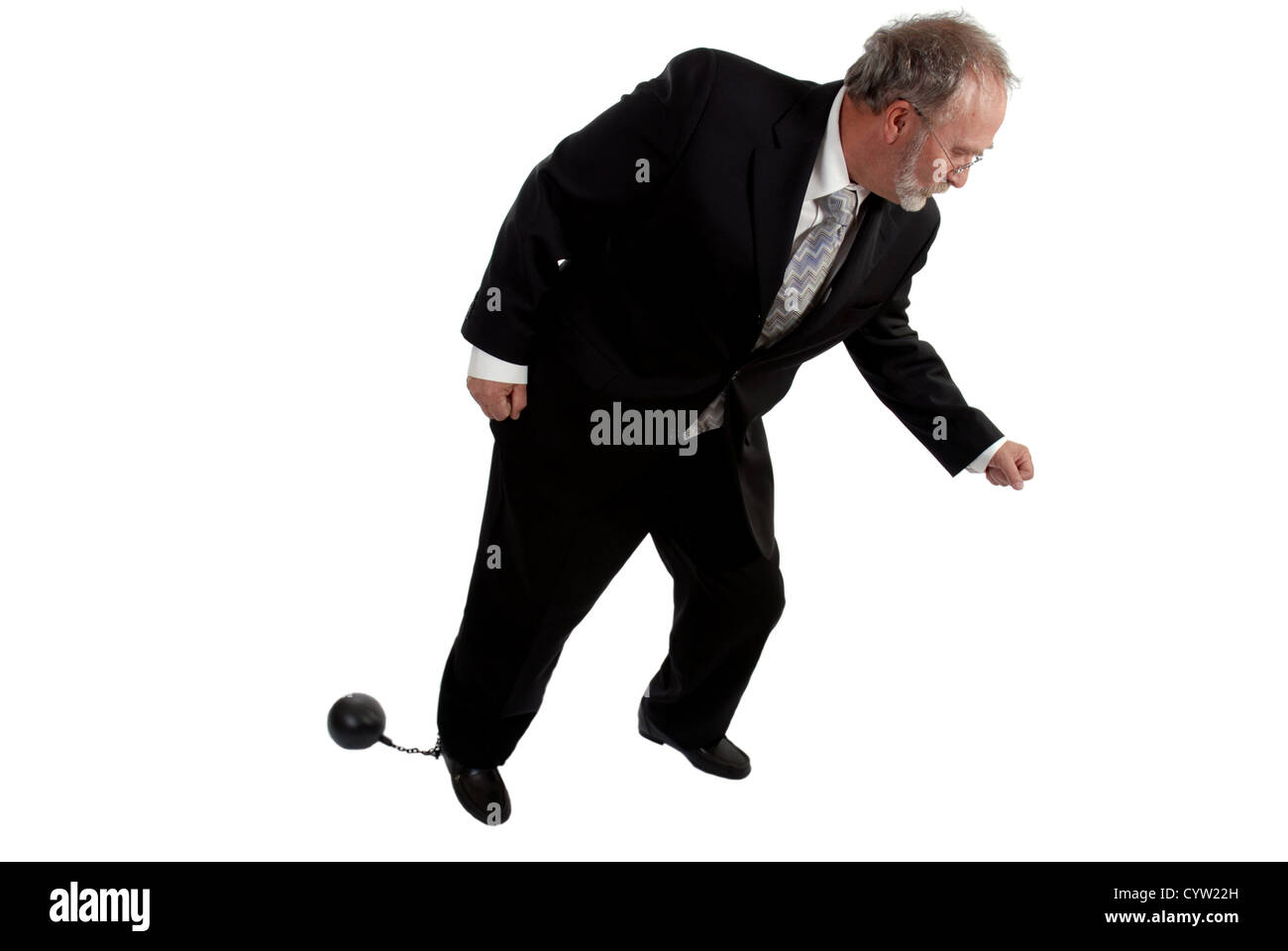 Businessman tring to move with a ball and chain attached to his leg Stock Photo