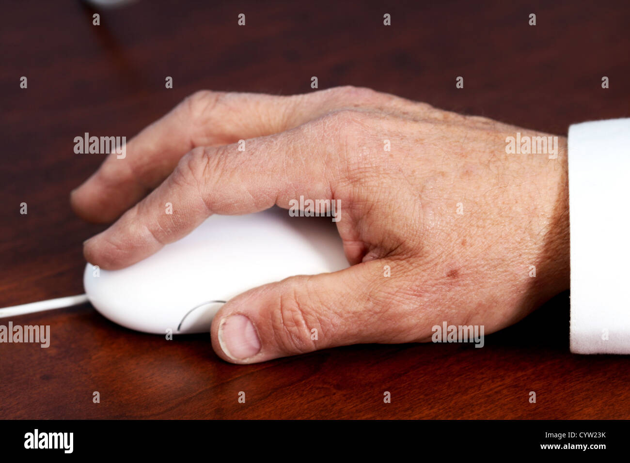 Elderly hand using a computer mouse on a desk Stock Photo Alamy