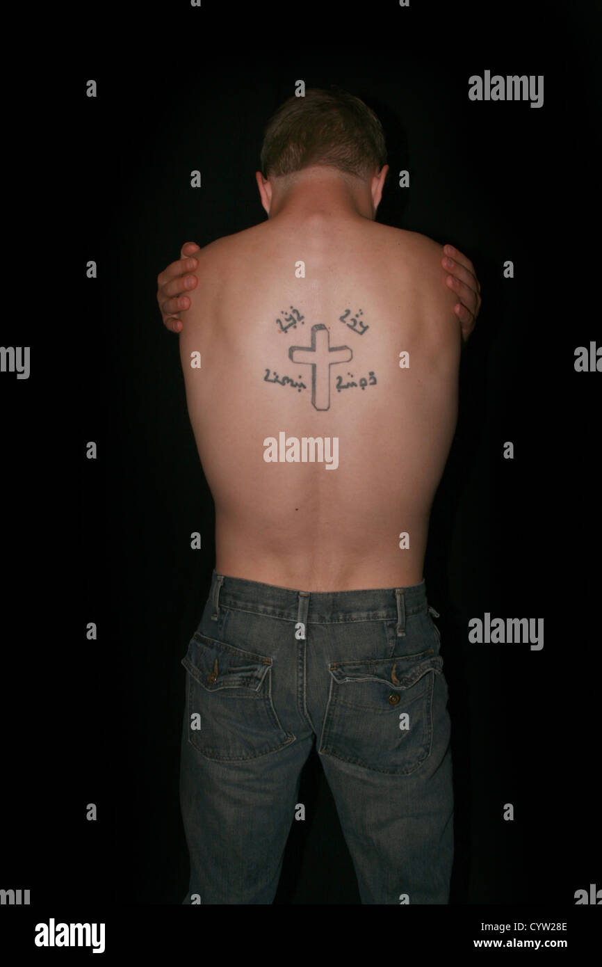 A topless man hugging himself, his back showing a crucifix tattoo Stock Photo - Alamy A topless man hugging himself, his back showing a crucifix tattoo Stock Photo - Alamy
