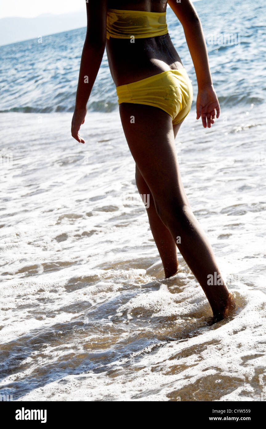 A young girl walking on a beach Stock Photo
