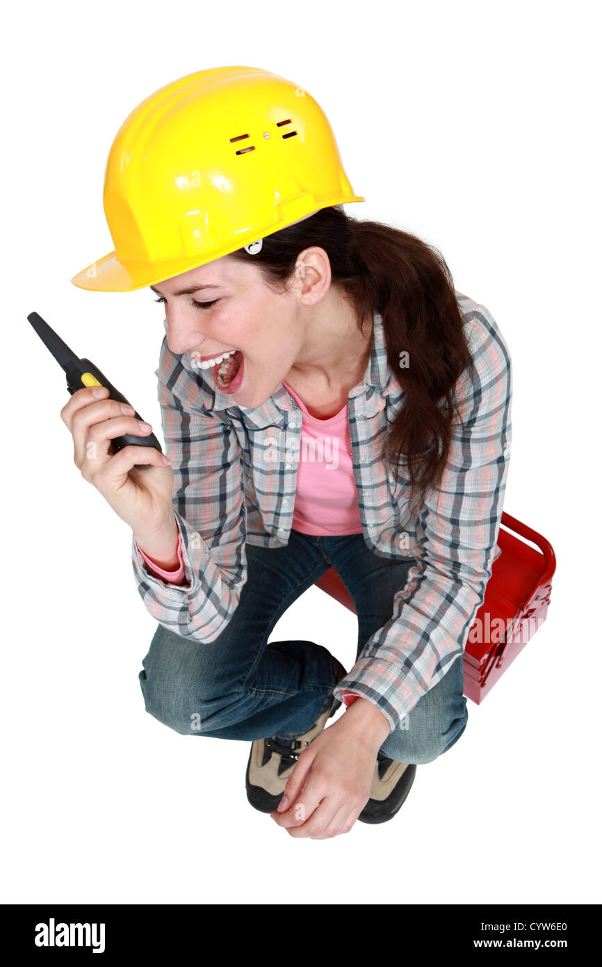 Woman sitting on toolbox with radio in hand Stock Photo