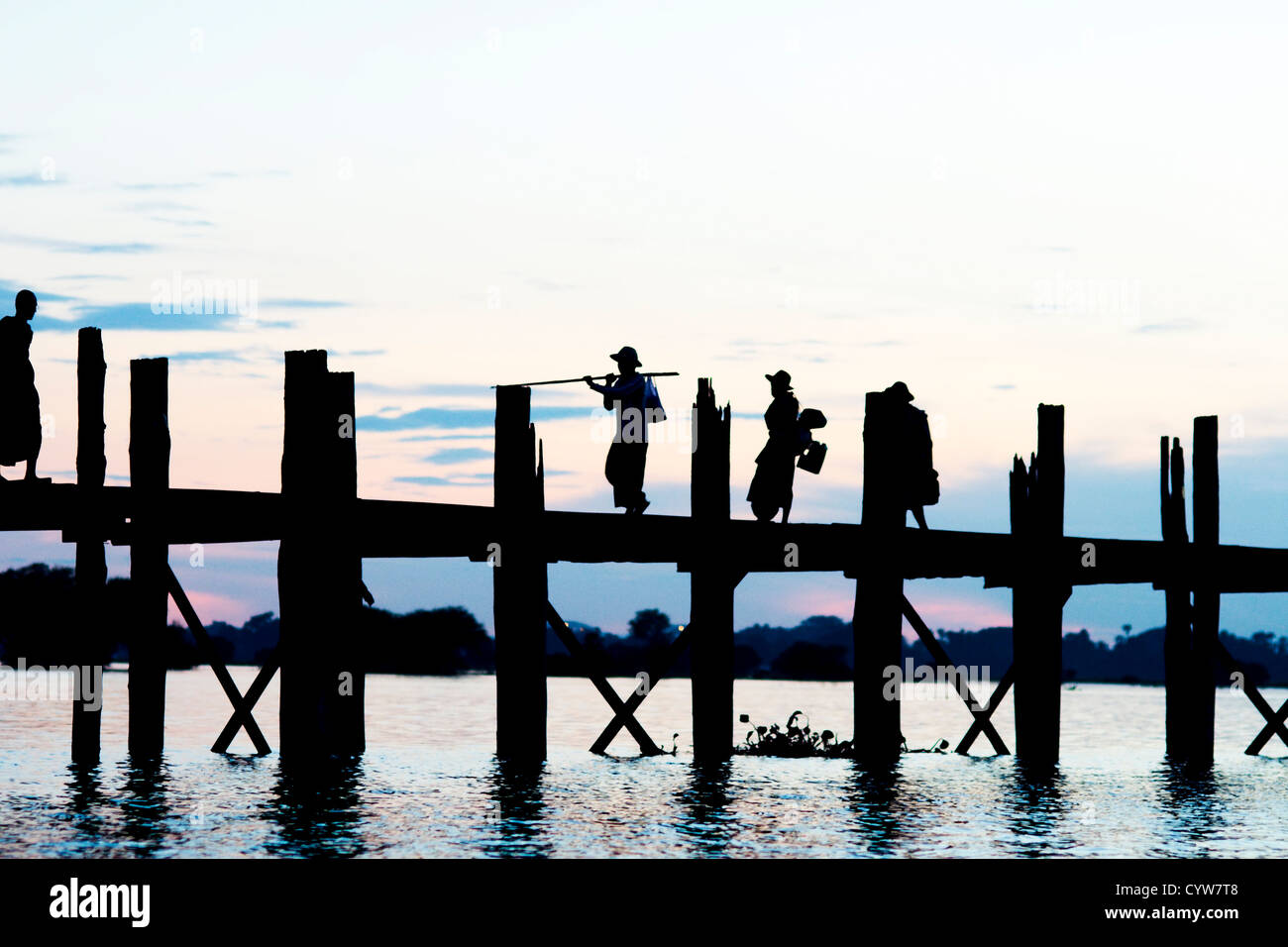 People crossing the U Bein bridge by dusk Stock Photo - Alamy
