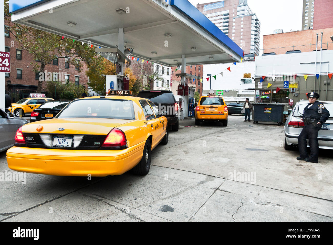 Woman police officer monitoring vehicle access to pumps at west side Manhattan service station on November 10th 2012, the 2nd day of gas rationing in New York City USA. Orders from Mayor Michael Bloomberg and Governor Andrew Cuomo restrict private owners to buying fuel for their vehicles on either odd- or even-numbered days, depending on the last digit of their license numbers. Commercial vehicles are exempt. Stock Photo