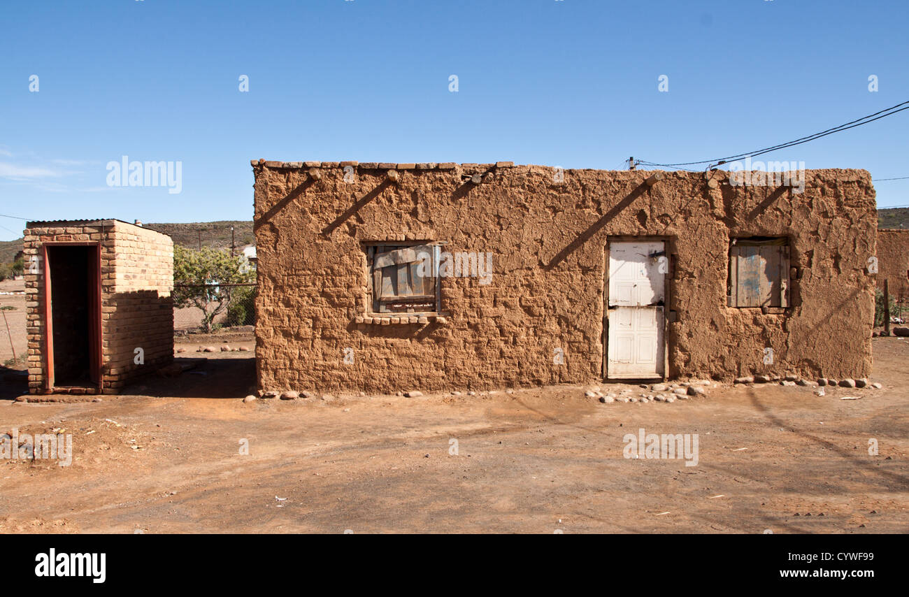 Mud hut complete with the long drop toilet to the side, they even have a phone. This is in Van Wyksvlei Northern Cape SA. Stock Photo