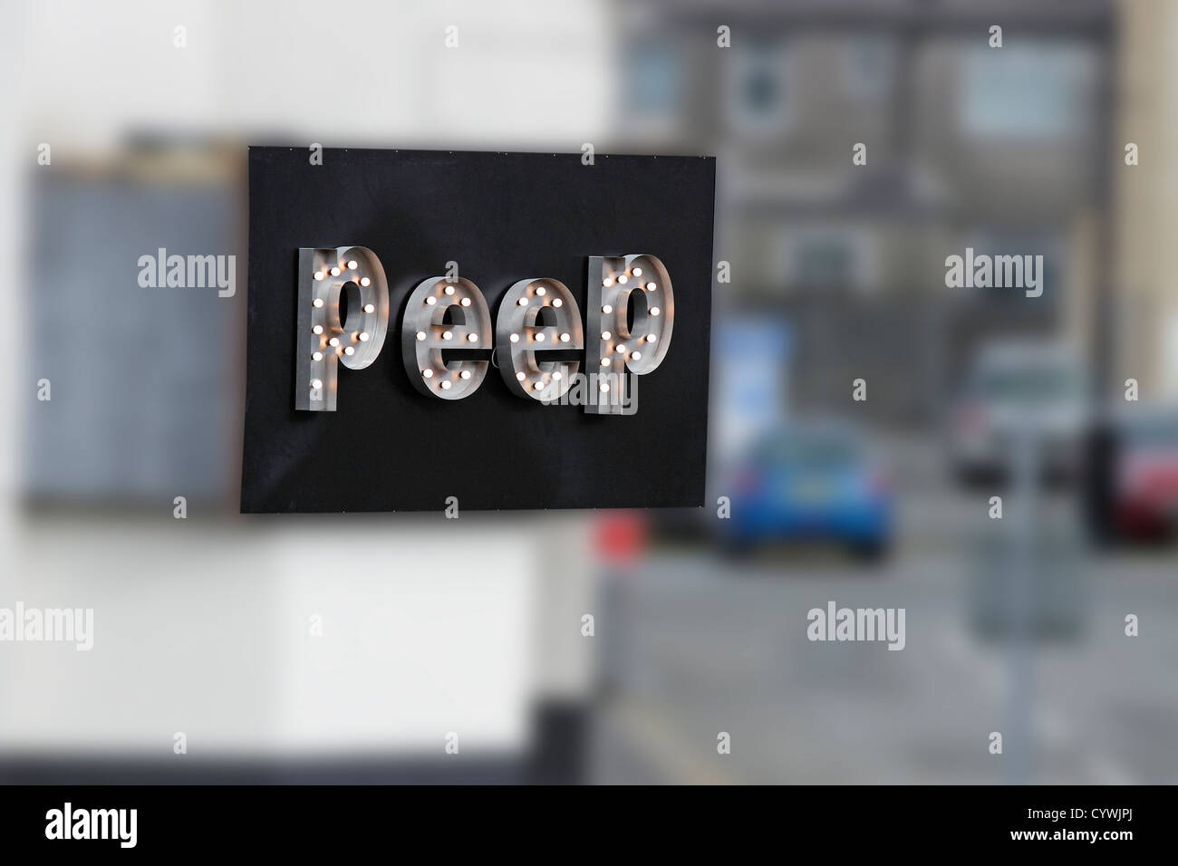 A sign on shop wall in North Wales bearing the word 'PEEP' Stock Photo