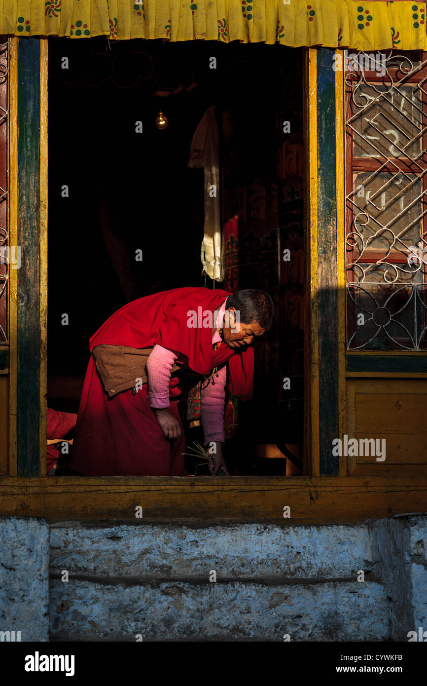 Female Buddhist monk sweeping the floor inside the Galden Namgey Lhatse Monastery, Arunachal Pradesh, India Stock Photo