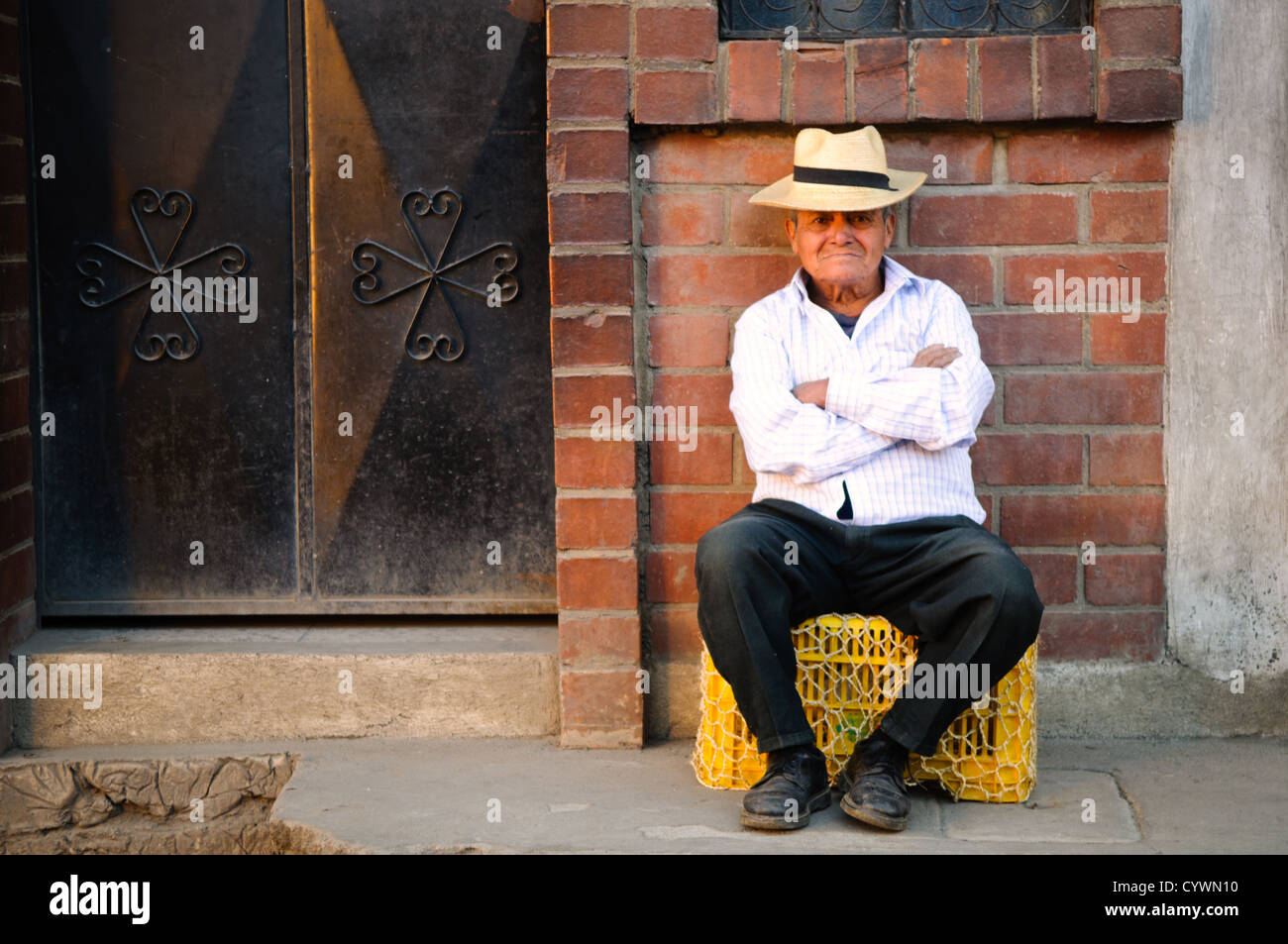 CHICHICASTENANGO, Guatemala - A man sits for a photo on the street in Chichicastengo, Guatemala. Chichicastenango is an indigenous Maya town in the Guatemalan highlands about 90 miles northwest of Guatemala City and at an elevation of nearly 6,500 feet. It is most famous for its markets on Sundays and Thursdays. Stock Photo