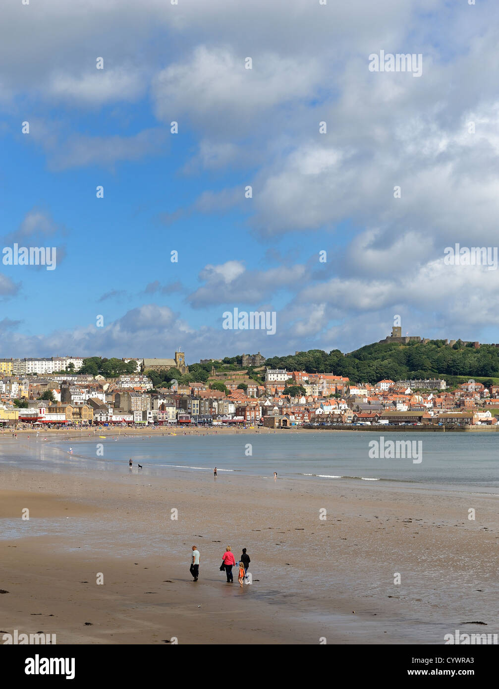 A family walking across scarborough beach north yorkshire england uk Stock Photo