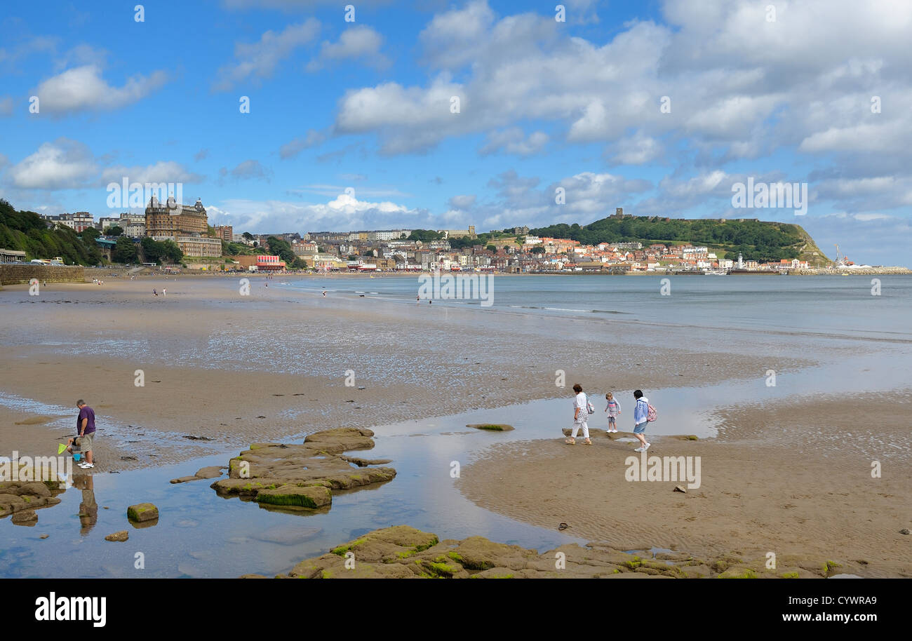 A family walking across scarborough beach north yorkshire england uk Stock Photo
