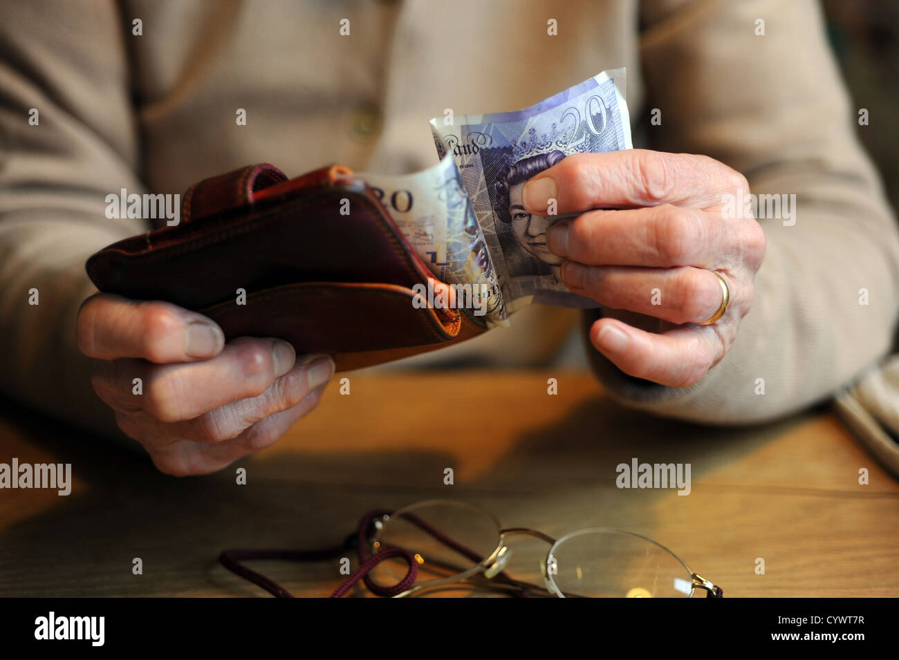 female pensioner holding money in her arthritic hands Stock Photo