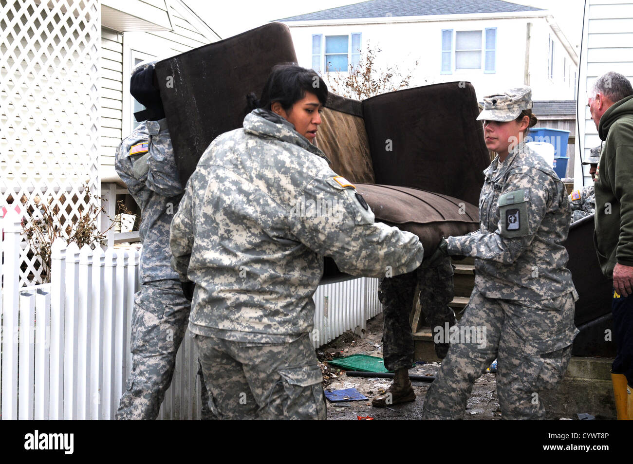 Soldiers from the 227th Preventive Medicine Detachment, 56th Multifunctional Medical Battalion, 62nd Medical Brigade, out of Joint Base Lewis-McChord, Wash., assist citizens in Breezy Point, N.Y., in removing damaged furniture from a house Nov. 10. The so Stock Photo