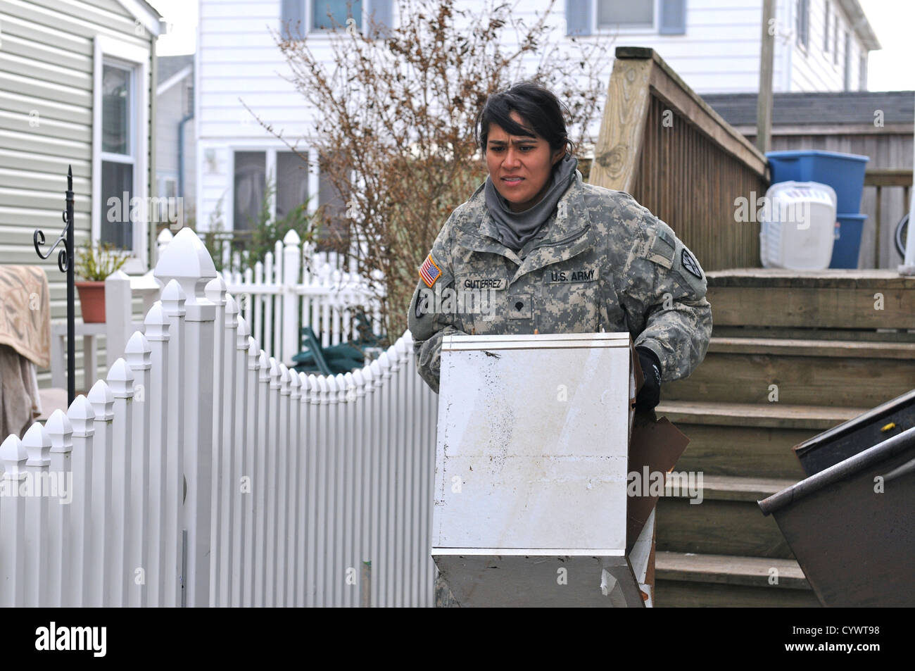 Spc. Maria R. Gutierrez, a preventive medicine specialist from the 227th Preventive Medicine Detachment, 56th Multifunctional Medical Battalion, 62nd Medical Brigade, out of Joint Base Lewis-McChord, Wash., assists citizens in Breezy Point, N.Y., in remov Stock Photo