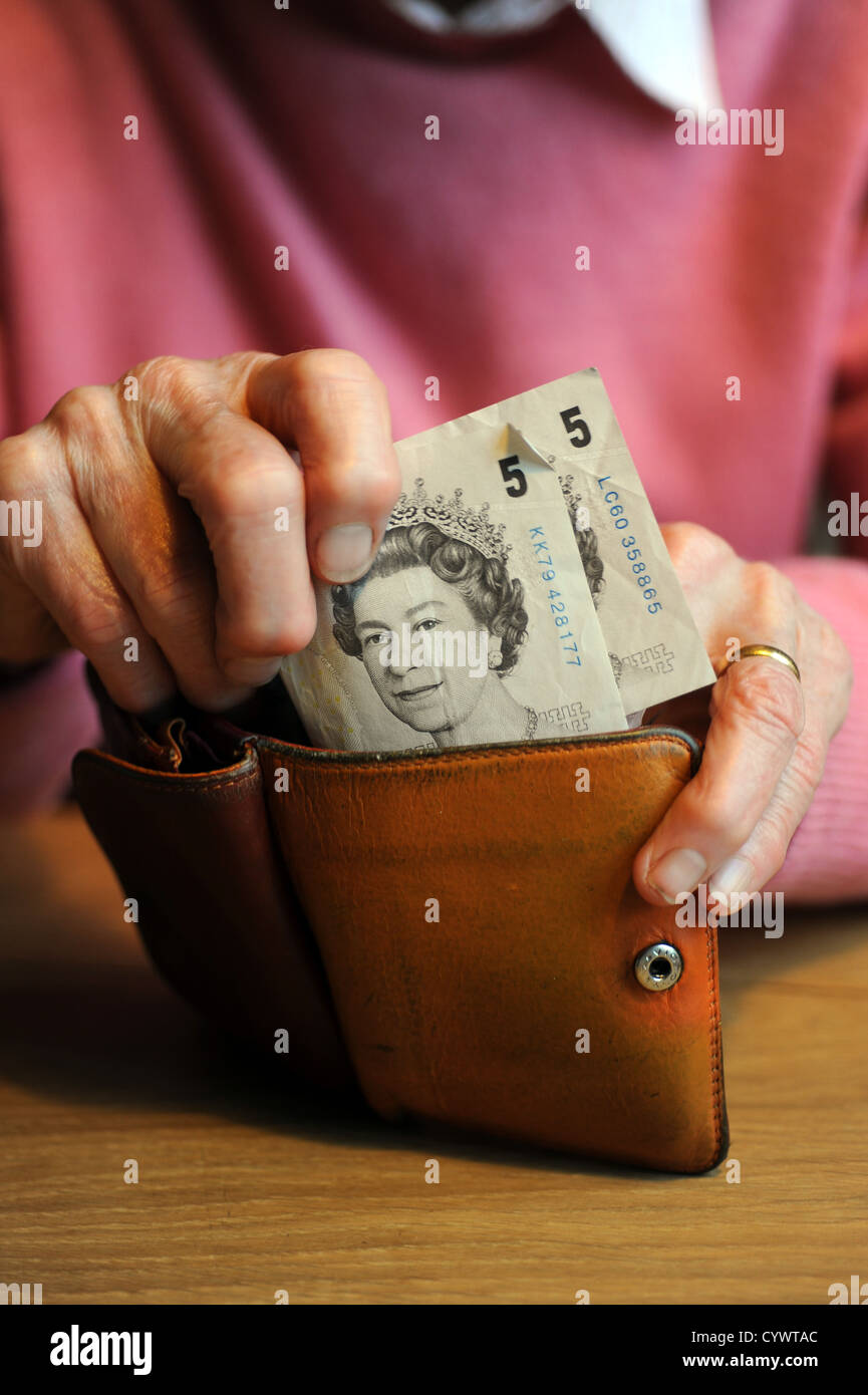 female pensioner holding money in her arthritic hands Stock Photo