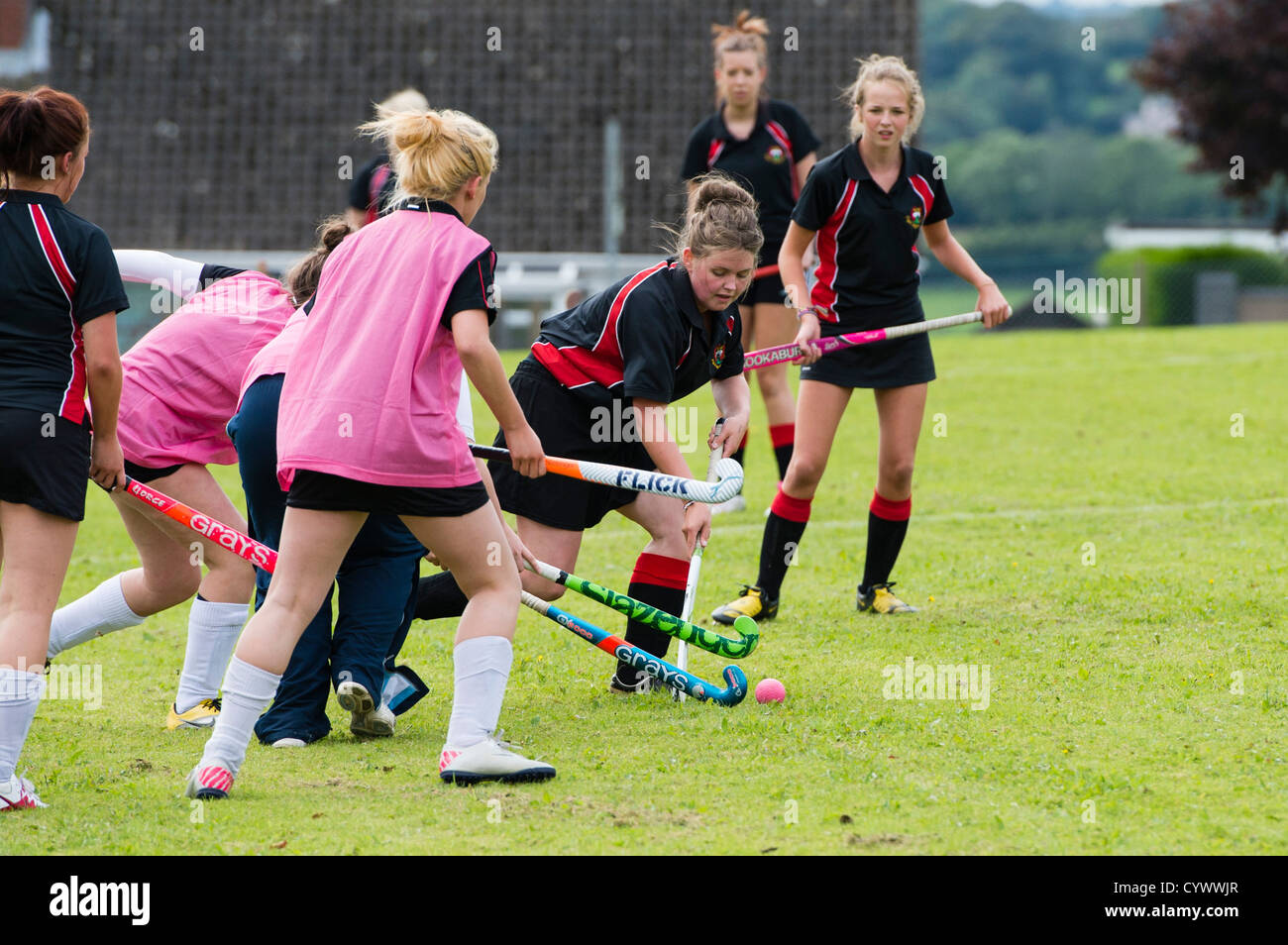 Team Sports and Physical education : Two sides of teenage girls playing hockey outdoors at a secondary comprehensive school, Wales UK Stock Photo