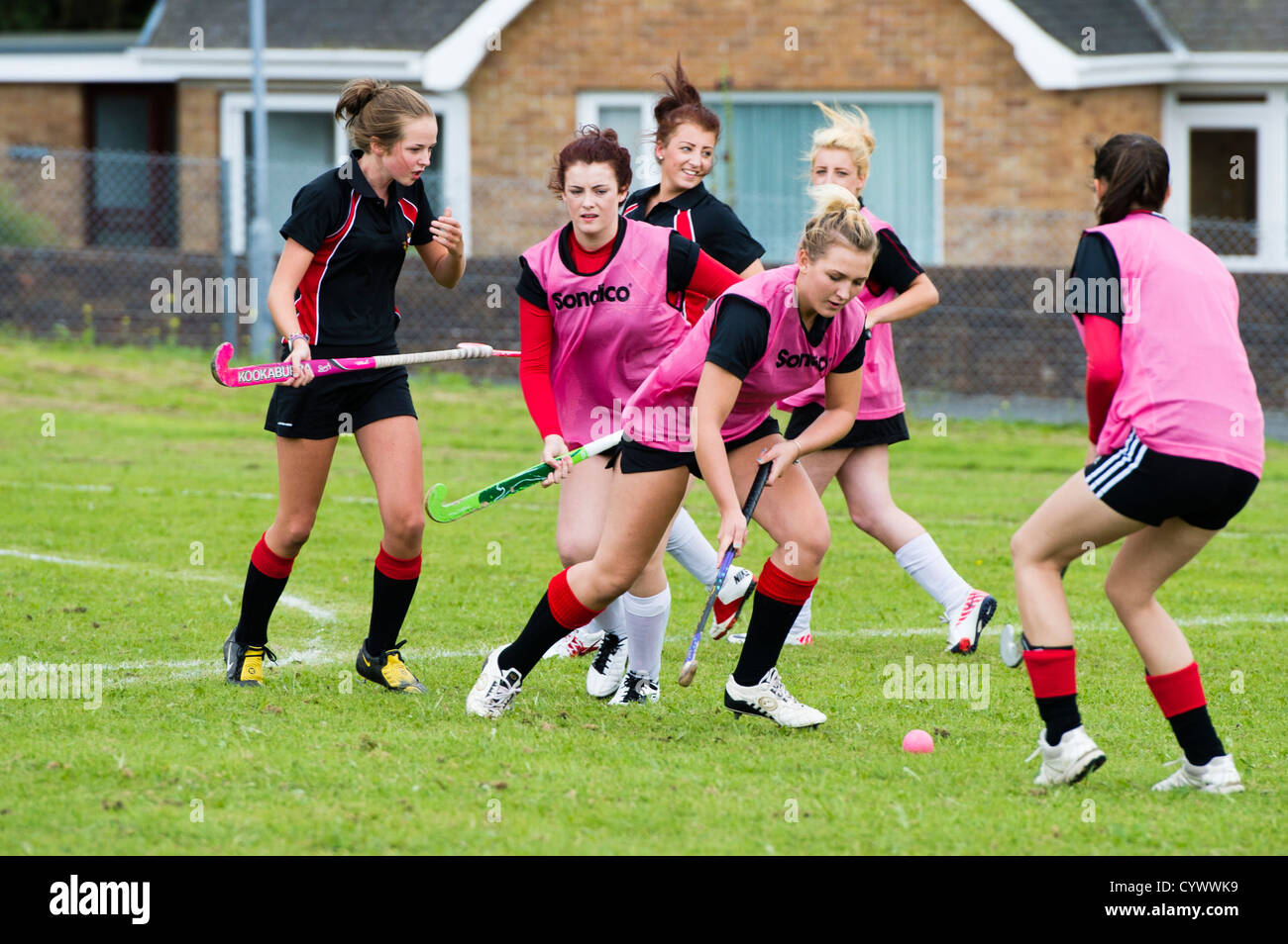 Teenage girls playing hockey outdoors at a secondary comprehensive school, Wales UK Stock Photo