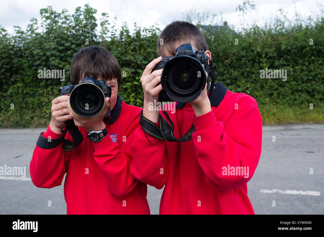 Two teenage boys using generic DSLR cameras learning photography in a