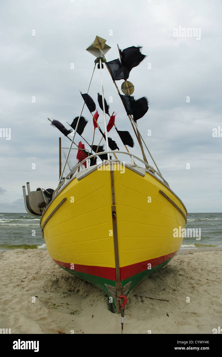 A yellow fishing boat on the Baltic shore on June 14, 2012 in Katy Rybackie, Pomerania, Poland Stock Photo