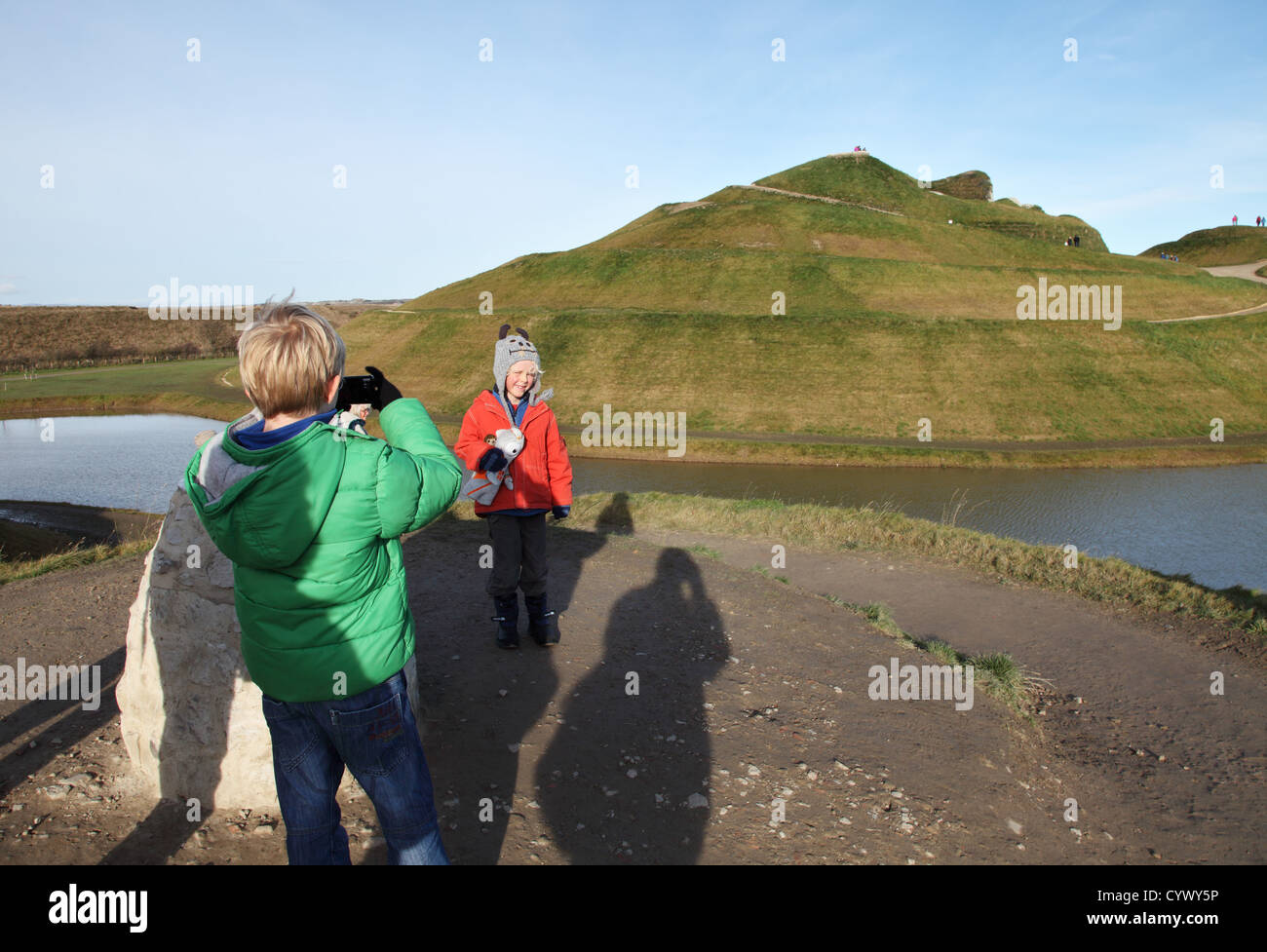 Boy taking photo of young girl at Northumberlandia public art sculpture north east England UK Stock Photo