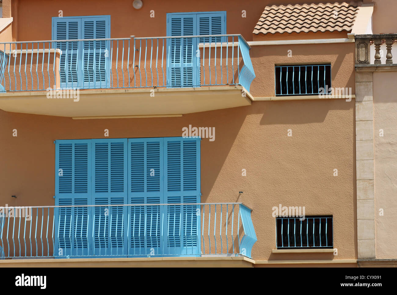 Exterior of Spanish homes with balcony and shuttered windows. Stock Photo