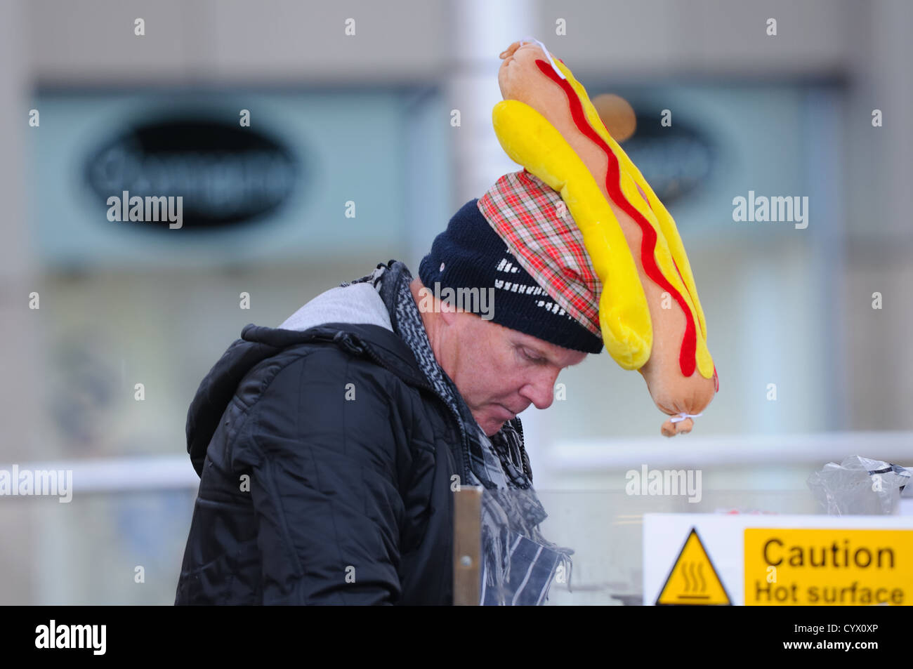 Street food vendor wearing funny hot dog hat in Paisley, Scotland. Stock Photo