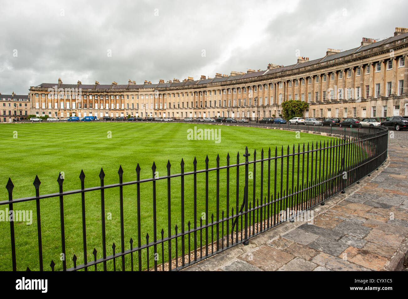 BATH, UK - A large grassed park in front of the Royal Crescent in Bath, Somerset. The Royal Crescent is a street of 30 terraced houses laid out in a sweeping crescent in the city of Bath, England. Designed by the architect John Wood the Younger and built between 1767 and 1774, it is among the greatest examples of Georgian architecture to be found in the United Kingdom and is a Grade I listed building. Although some changes have been made to the various interiors over the years, the Georgian stone façade remains much as it was when it was first built. Stock Photo