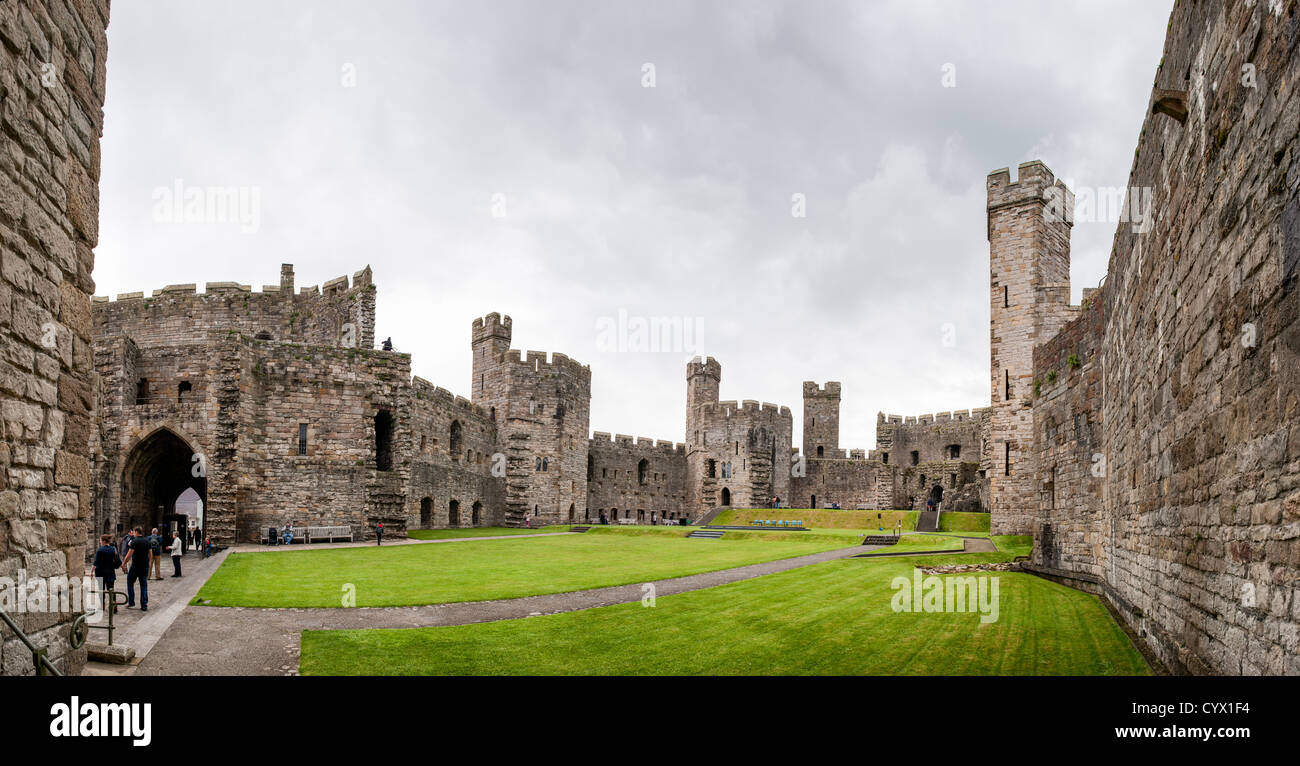 CAERNARFON, Wales - A panorama from inside the walls at Caernarfon Castle in northwest Wales. A castle originally stood on the site dating back to the late 11th century, but in the late 13th century King Edward I commissioned a new structure that stands to this day. It has distinctive towers and is one of the best preserved of the series of castles Edward I commissioned. Stock Photo