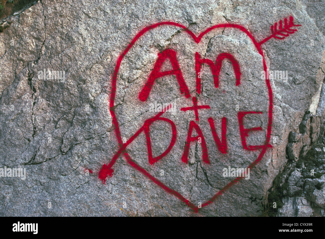 True Love Heart and Romance - Names and Initials written in Red Paint on a Rock - Heart-Shaped Romantic Graffiti Drawing Stock Photo