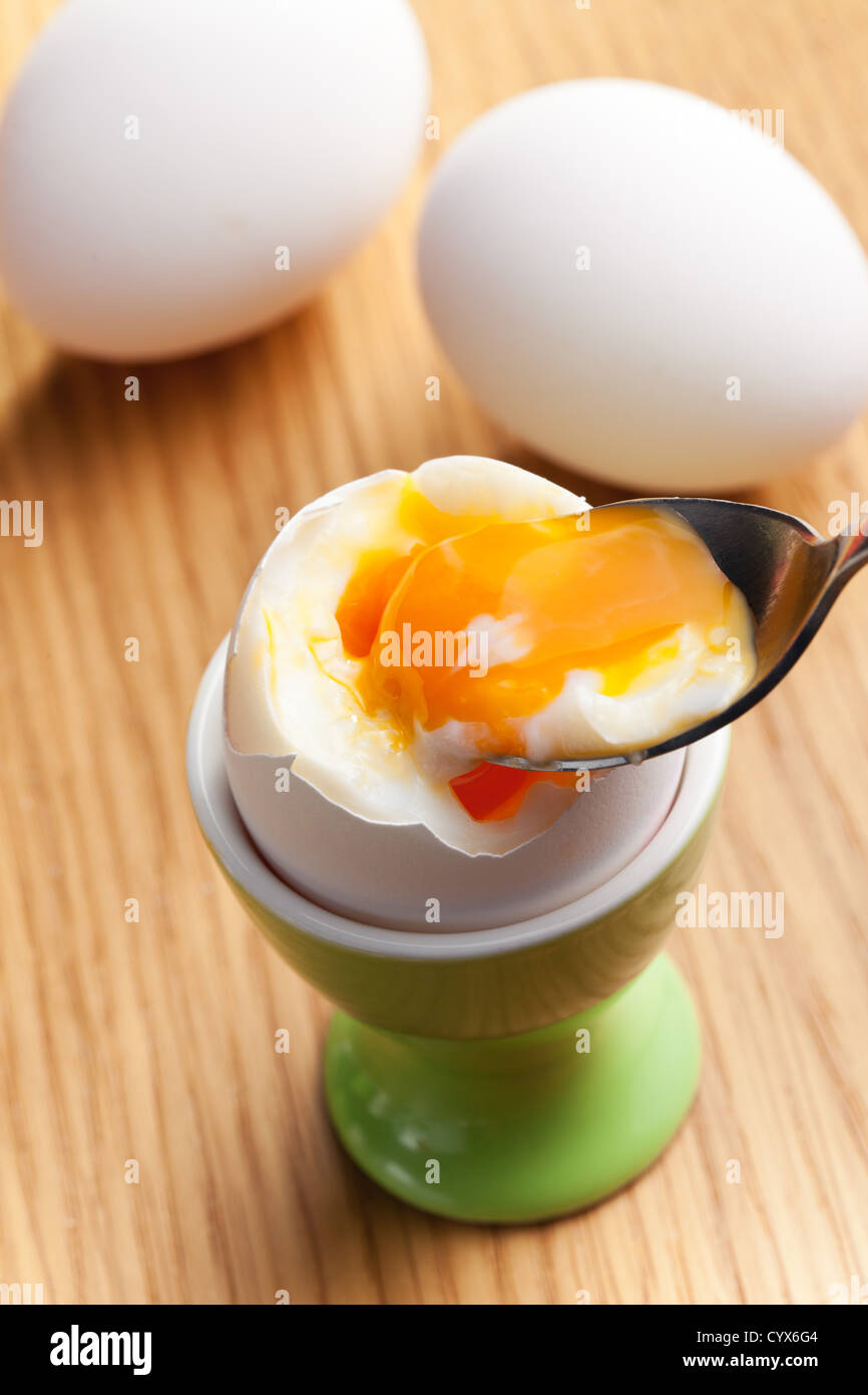 boiled egg in eggcup on wooden table Stock Photo